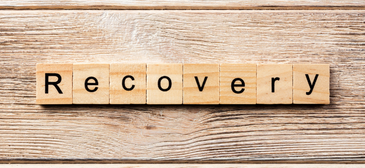 Wooden Scrabble like tiles spelling out the word RECOVERY